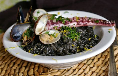  Risotto al Nero di Seppia: ความหอมมันของเนื้อหมึกและความเข้มข้นของครีมผสานกันอย่างลงตัวในจานข้าวอิตาลีโบราณ